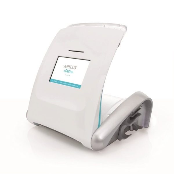 A white Apilus xCell Pur permanent hair removal device featuring a digital display screen showing 27.12 MHz technology.